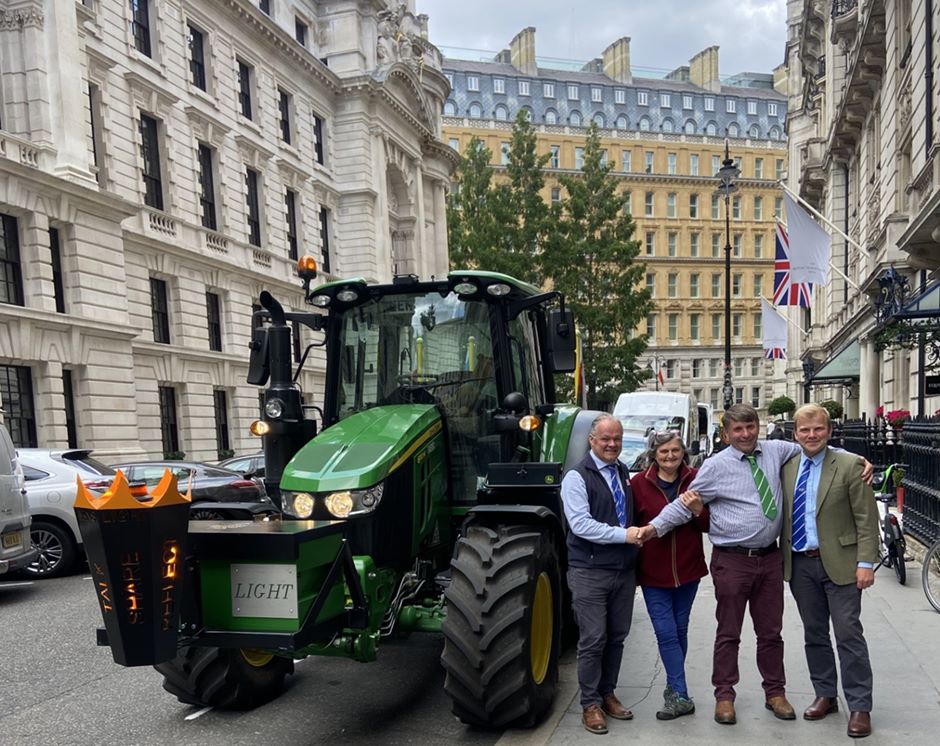 Picture of the John Deere tractor used in the relay parked in London. Pictured are: Hugh Brown, CEO of Melton Mowbray Market; Lynda and Andy Eadon; and Scott Ruck, auctioneer and head of sales at Melton Mowbray Market.