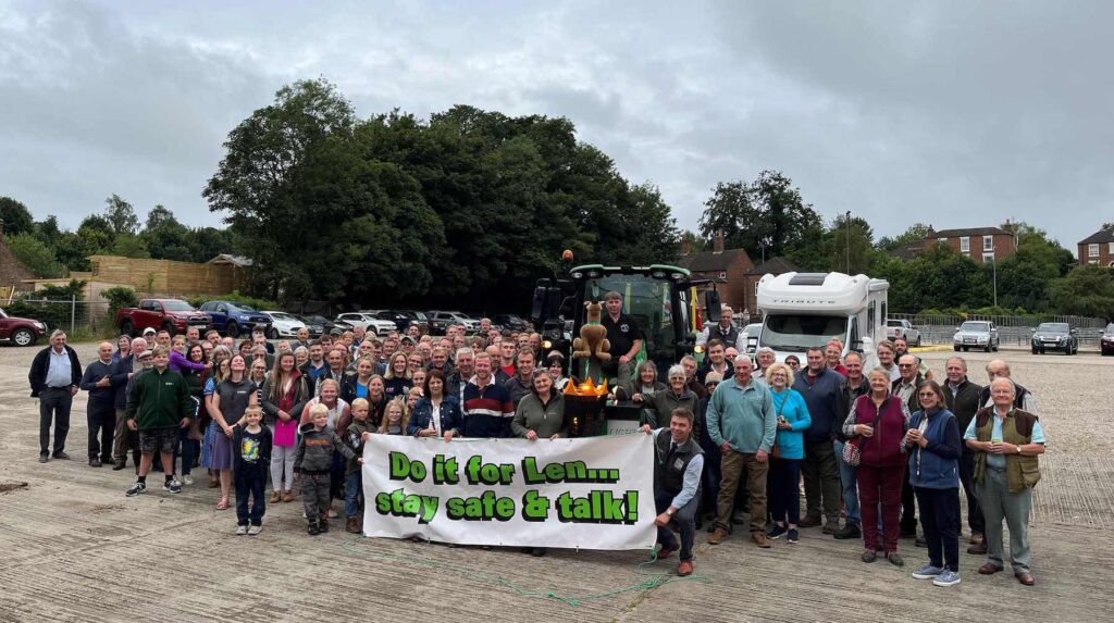 A group shot of people who attended a charity evening at Louth Livestock Market. They are holding a sign that reads: 'Do it for Len... Stay safe and talk'.