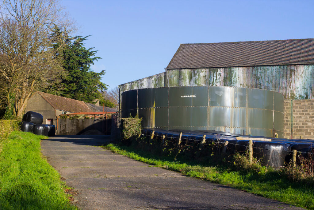 Slurry tank on a farmyard in Northern Ireland, with farm buildings in the background