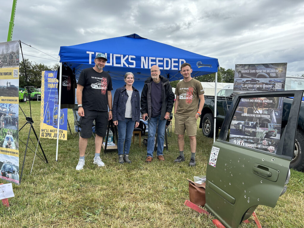 Pictured at the Kent County Show are Car for Ukraine co-founder Nazar Kravchuck, Judy and John Barber, and Car for Ukraine co-founder Ivan Oleksii. They stand in front of the Car for Ukraine marquee, and to the right is a door from an armoured car used by the Ukrainian Army, with bullet damage.